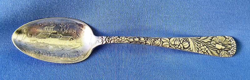 Souvenir Mining Spoon Anaconda  Mine.JPG - SOUVENIR MINING SPOON ANACONDA MINE - Sterling silver spoon embossed with a detailed picture of the Anaconda Mine Butte Montana; with floral design on handle, 5 3/4 in long, marked on back Sterling with a mfg. hallmark  (The Anaconda Copper Mine was the largest copper-producing mine in the world from 1892 through 1903.  Located in Butte, Montana it transformed this small and poor town into one of the most prosperous cities in the country, often called the Richest Hill on Earth.  This small silver mine was bought in 1881 by Marcus Daly from Michael Hickey. Hickey was a prospector and Union Civil War veteran, and named his claim the Anaconda Mine after reading Horace Greeley's Civil War account of how Ulysses S. Grant's forces had surrounded Robert E. Lee's forces "like an anaconda". Daly then developed the Anaconda Mine in partnership with George Hearst, father of William Randolph Hearst, and James Ben Ali Haggin and Lloyd Tevis of San Francisco.  Huge deposits of another mineral, copper, were soon discovered.  Daly quietly bought up neighboring mines forming a mining company and would eventually own all the mines on Butte Hill. He then built a smelter at Anaconda which he connected to Butte by a railway. From this beginning grew the Anaconda Copper Mining Company, a global mining enterprise featuring the Anaconda and other Butte mines, a smelter at Anaconda, Montana, processing plants in Great Falls, Montana, the American Brass Company, and many other properties, mostly in the United States and Chile. The Anaconda Copper Mining Company was acquired by ARCO in 1977.  The Anaconda mine itself was closed in 1947 after producing 94,900 tons of copper. Its location has been consumed by the Berkeley Pit, a vast open-pit mine.  In 1977, Anaconda was sold to the Atlantic Richfield Company (ARCO) for $700 million.  By 1983 the Berkeley Pit was completely idle and ARCO suspended all operations in Butte.)